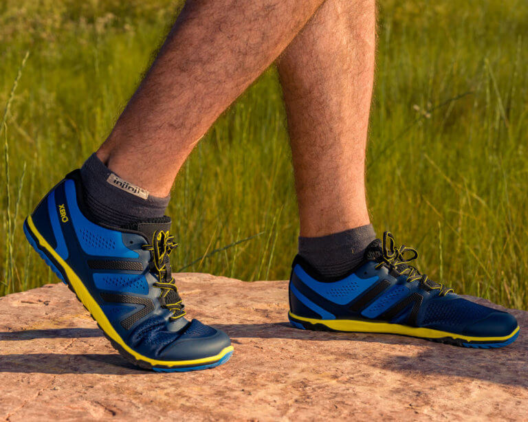 Primer plano de un hombre de pie sobre una roca con sus zapatillas de correr HFS II.