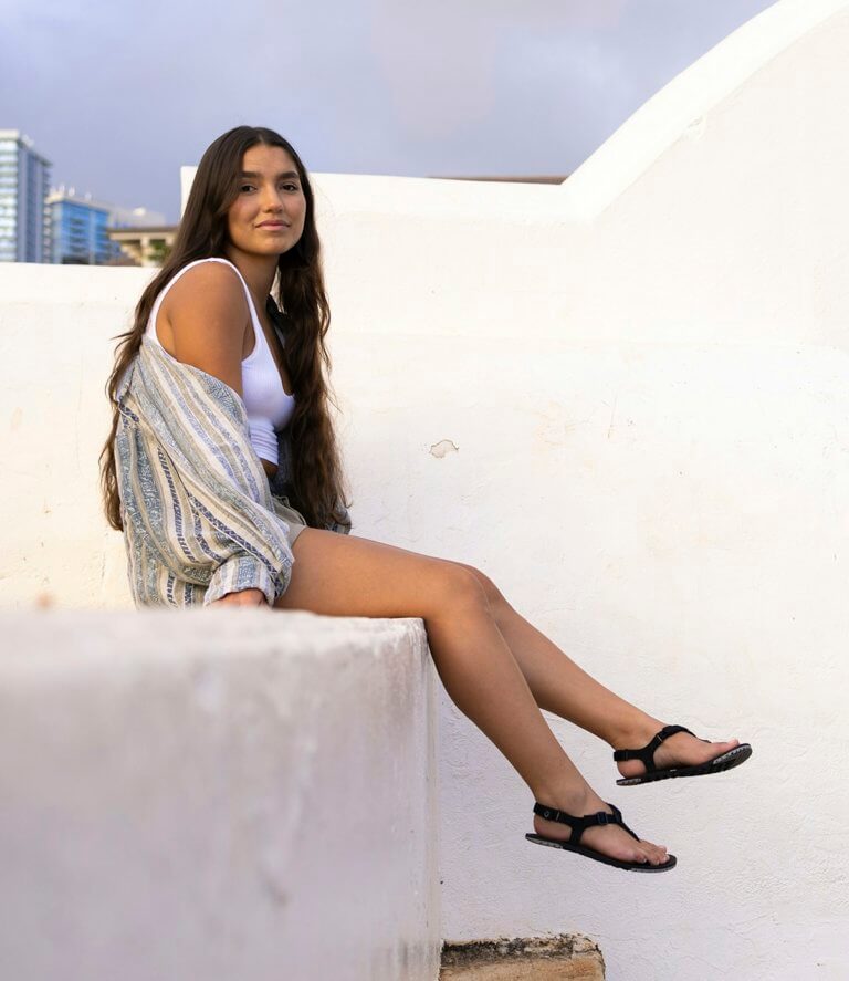 A woman wearing H-Trail sandals sitting outside carefree in warm weather