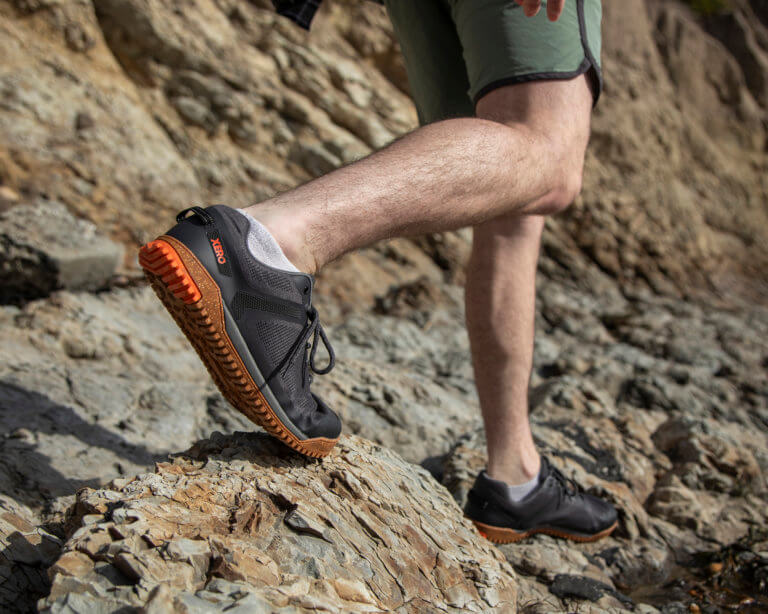 Un homme randonne sur un terrain rocailleux avec ses chaussures Rideway Mesh Low.