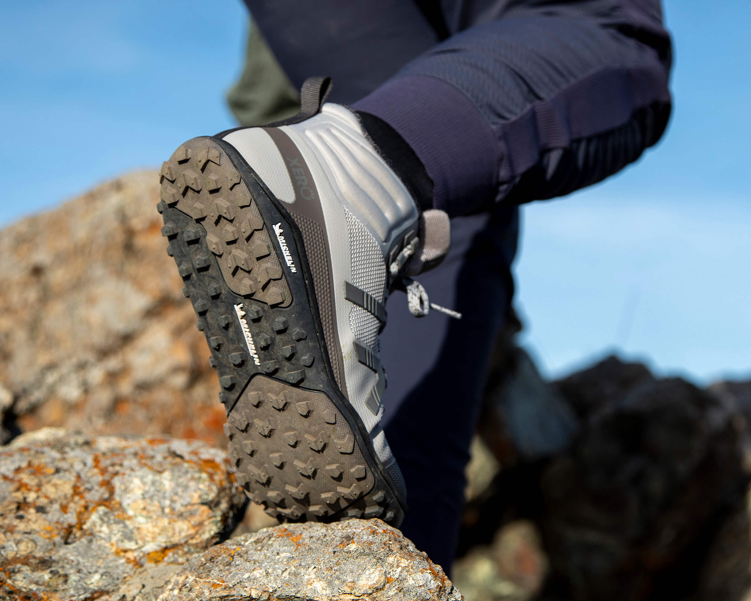 Gros plan sur une femme portant des bottes Scrambler Mid II et montrant leur semelle Michelin flexible avec une grande marche.