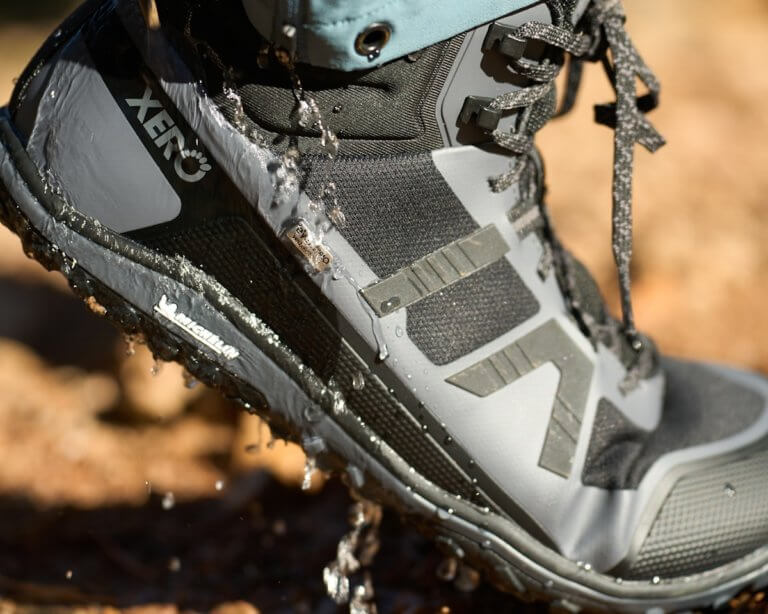 Een close-up opname van een man die Scrambler Mid II WP wandelschoenen draagt waarbij het water van de schoen druipt.